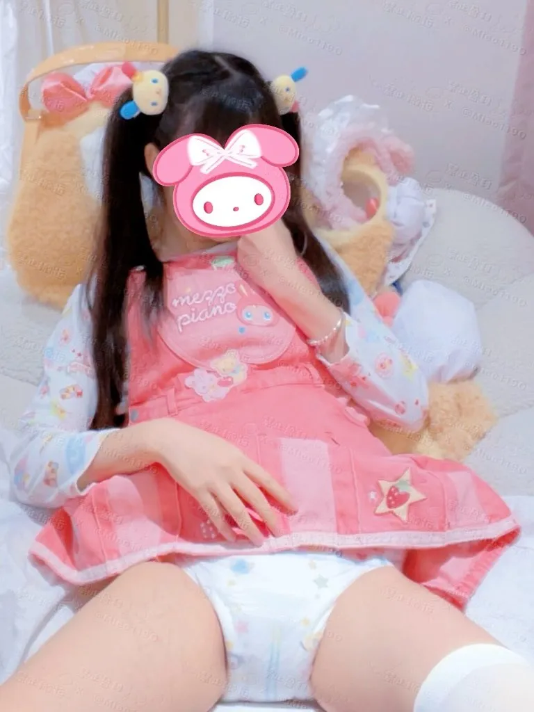 A girl wearing pink baby clothes and a diaper. She has white stockings on. Her thighs look plump.
