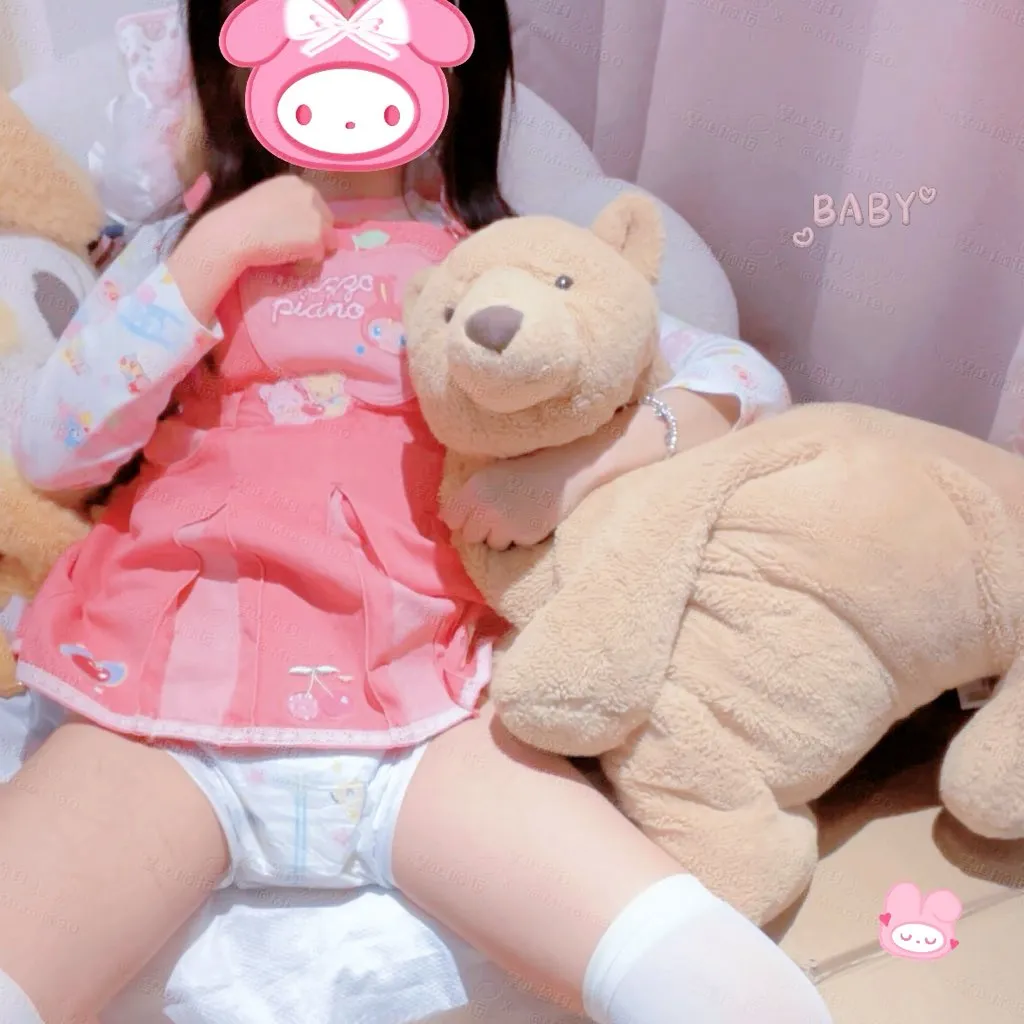 A girl wearing pink baby clothes and a diaper. She has white stockings on. Her thighs look plump.