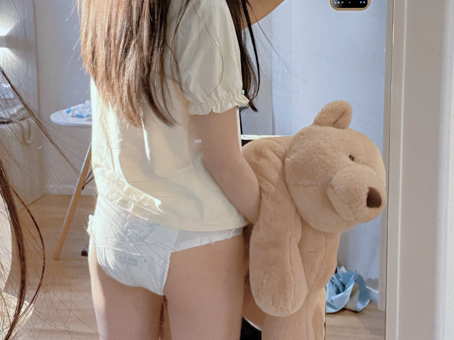 An ABDL girl hugging a teddy bear and wearing paper diapers