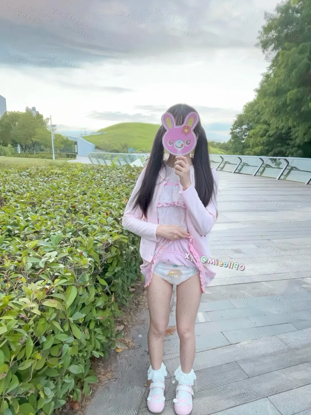 An ABDL girl lifting her skirt outdoors to show off her diaper