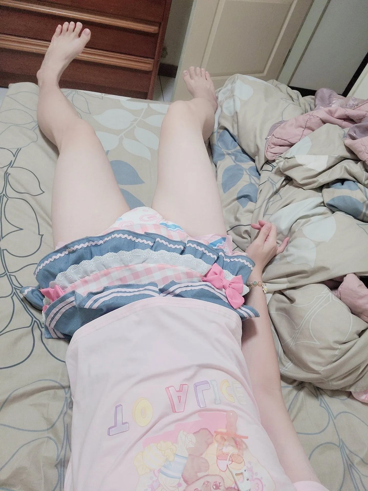 ABDL girl lying down with her skirt lifted to reveal her diaper
