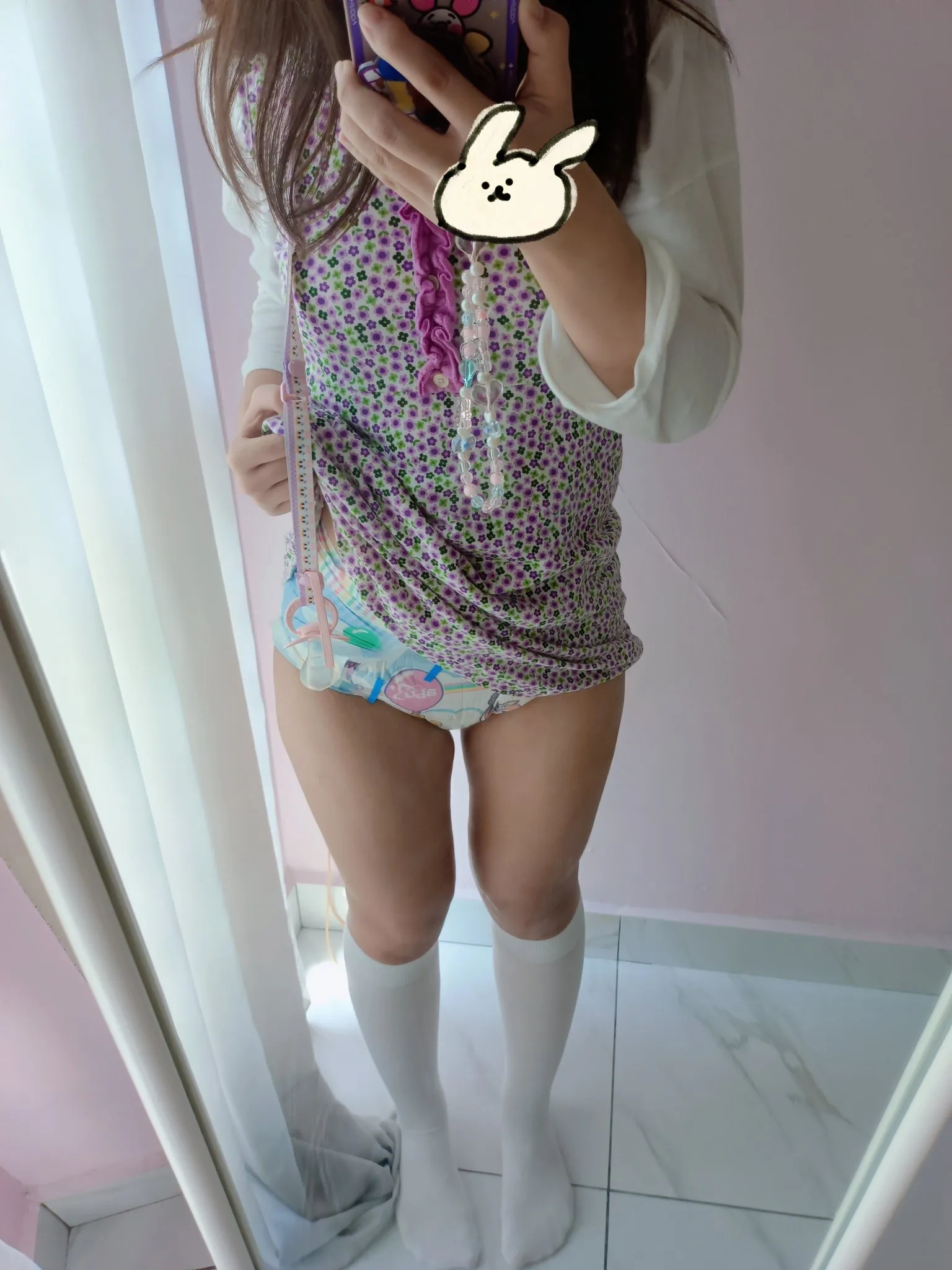 An ABDL girl lifts up her dress to show off her diaper.