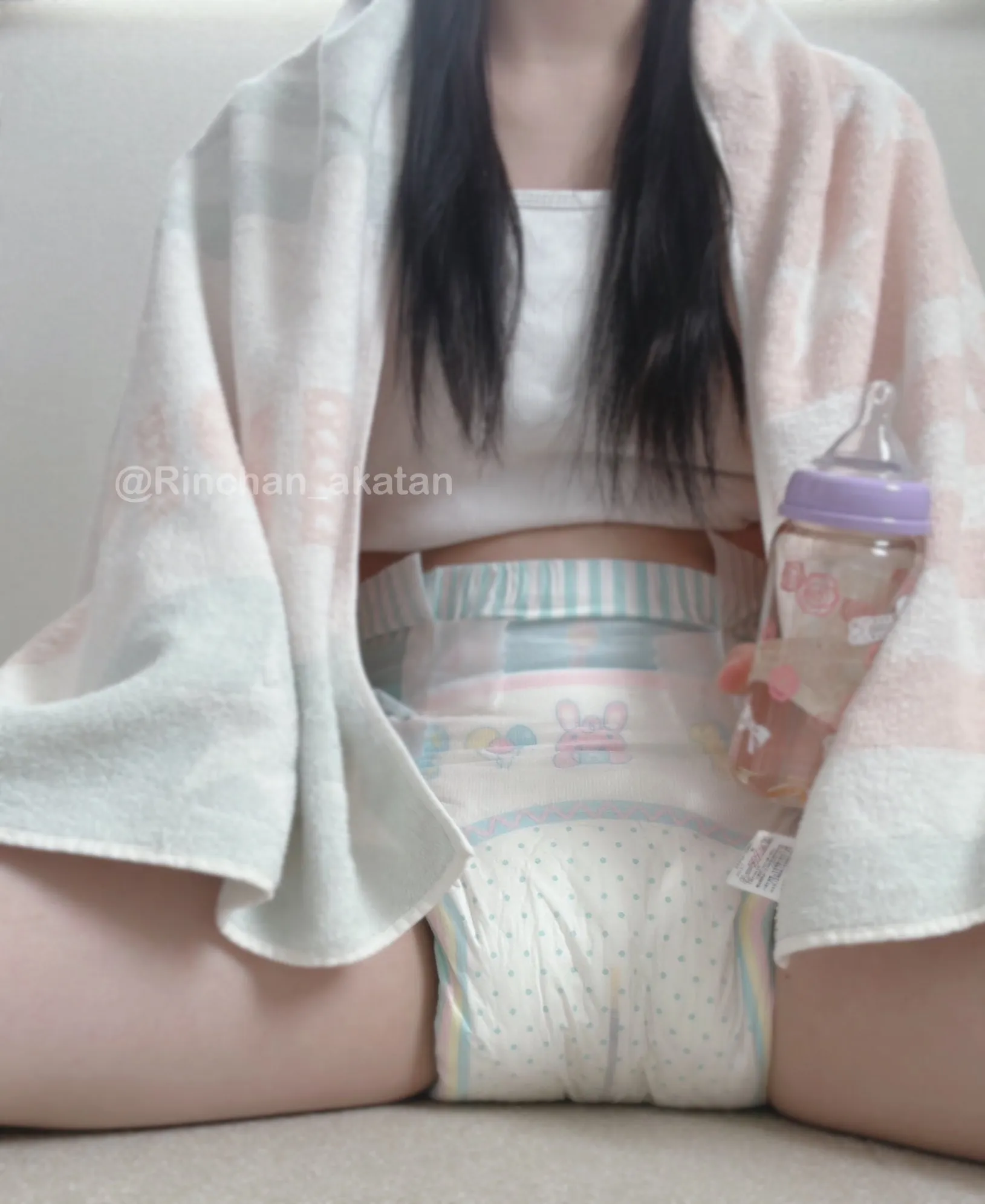 The ABDL girl is draped in a towel, and a cute ABDL diaper is visible beneath it.