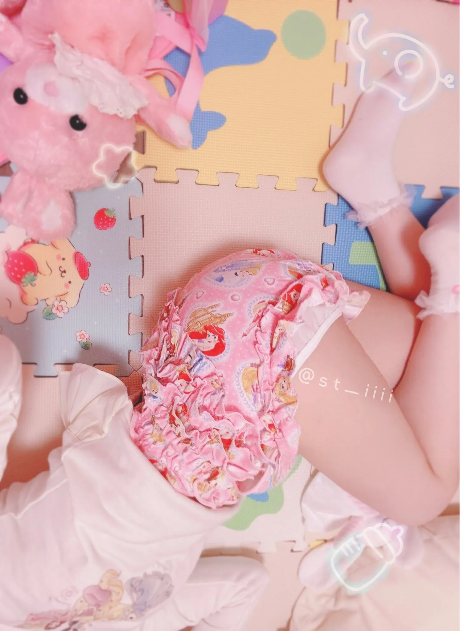 An ABDL girl is lying down wearing a pink diaper cover.
