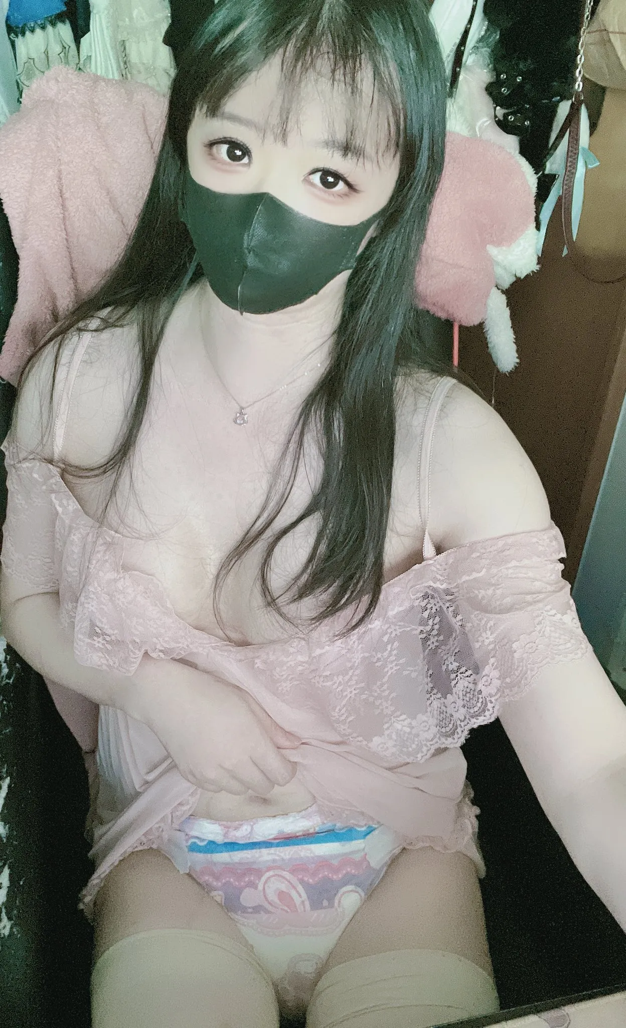 The ABDL girl lifts up her pajamas to show her ABDL diaper.