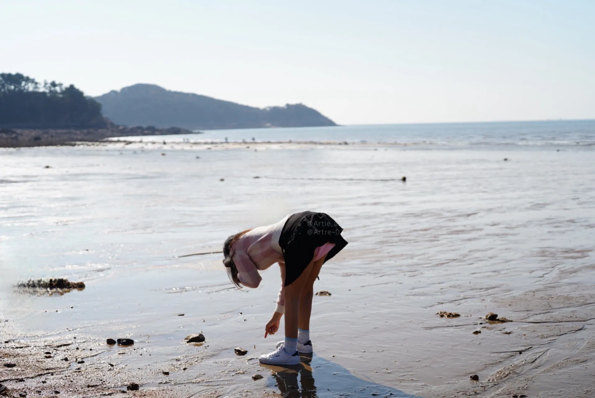 An ABDL girl is bending over outside, exposing the diaper under her skirt.