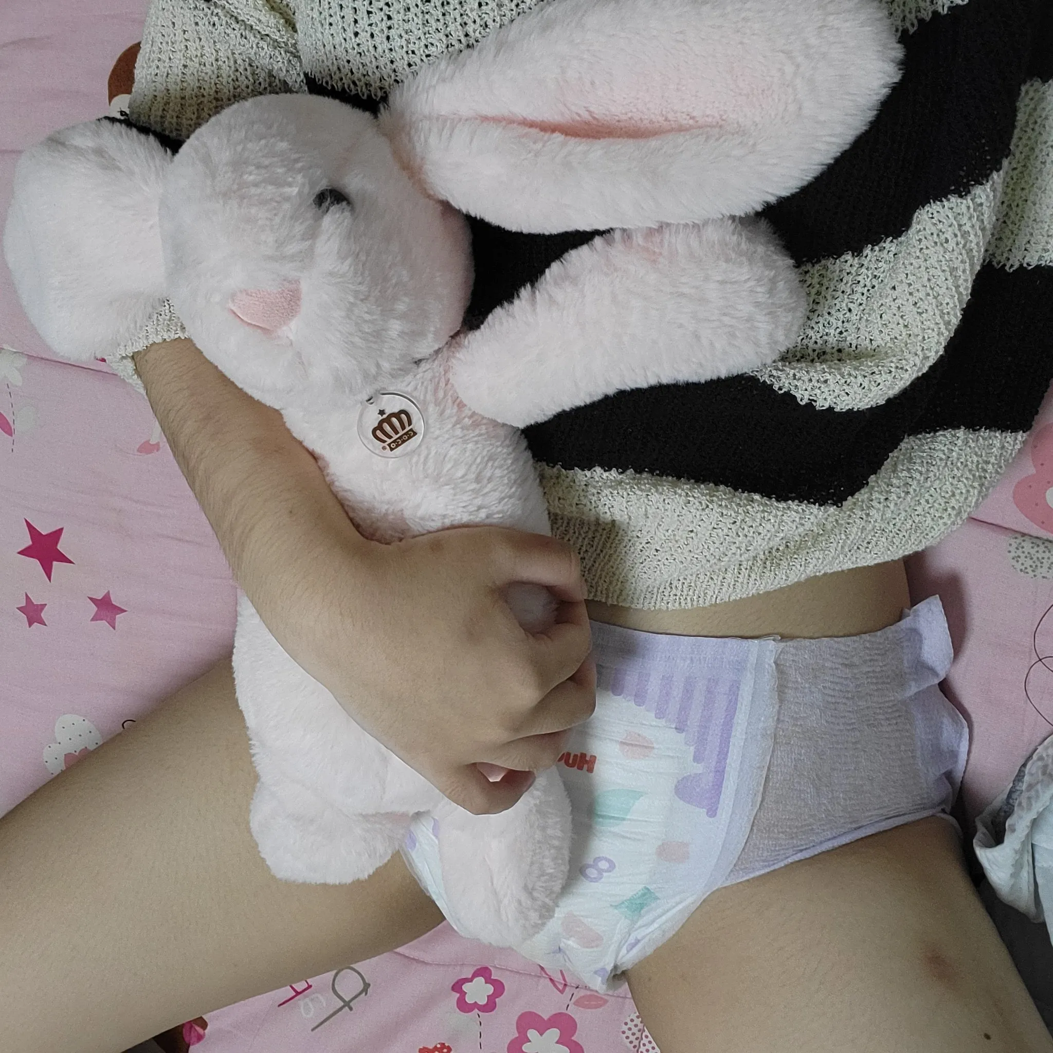 ABDL girl cradling a doll and showing off her diaper