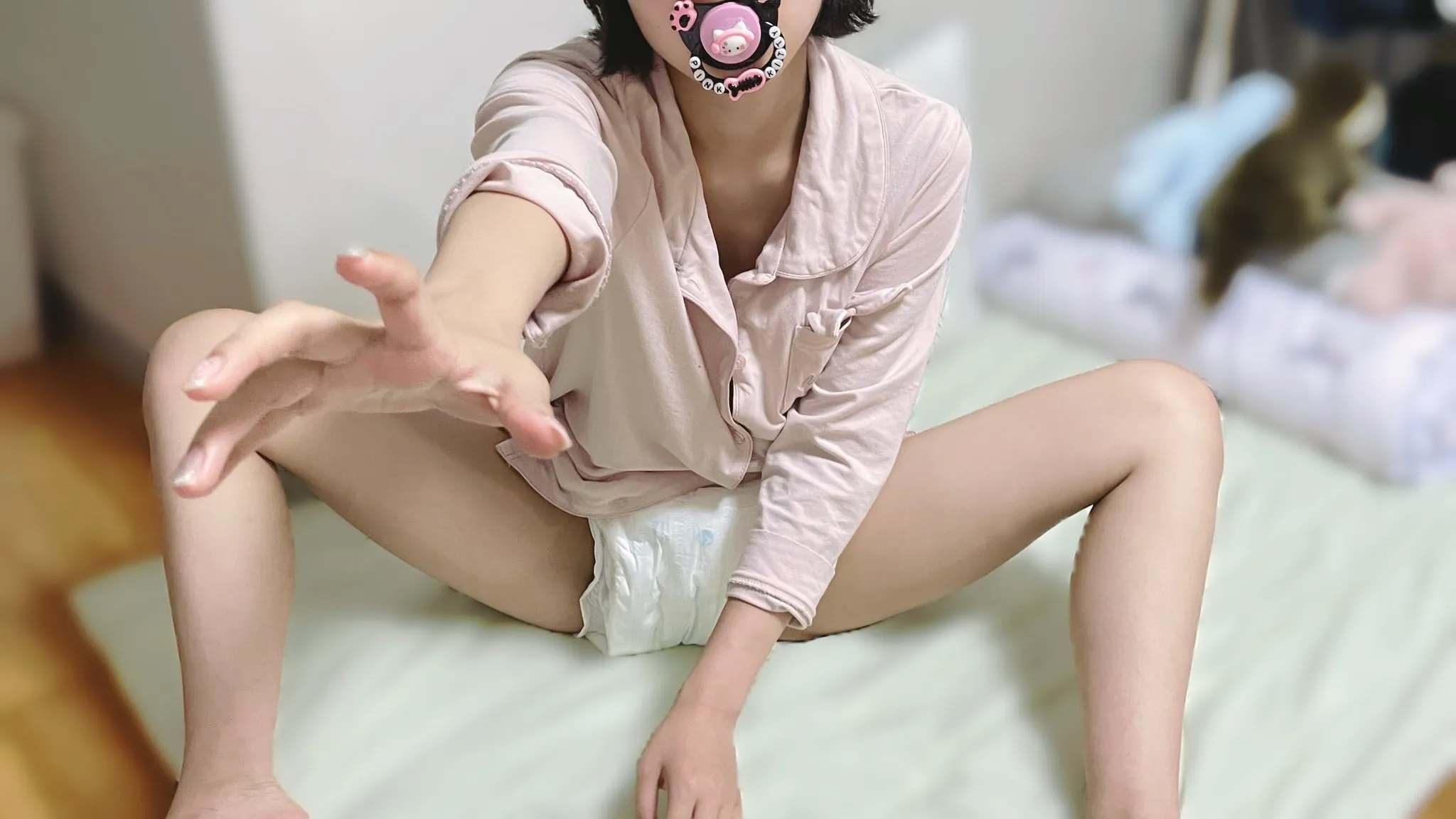 An ABDL girl wearing a white diaper, sucking on a pacifier and reaching out her hand