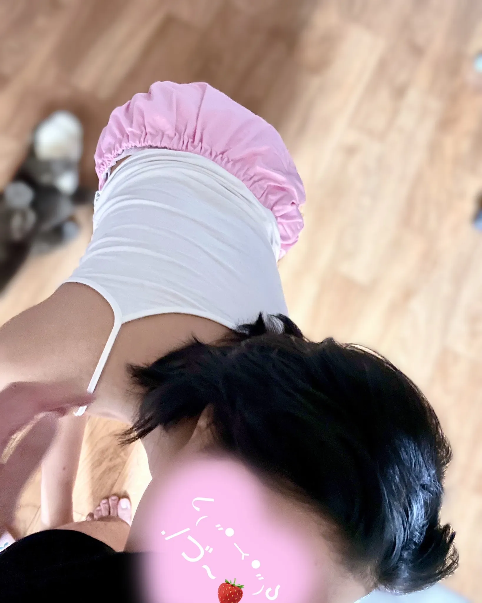 An ABDL girl wearing a tank top and diaper cover, sucking a man's cock