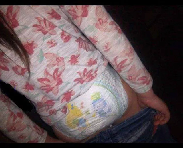 The diaper fetish girl pulled down her jeans, revealing her diaper.