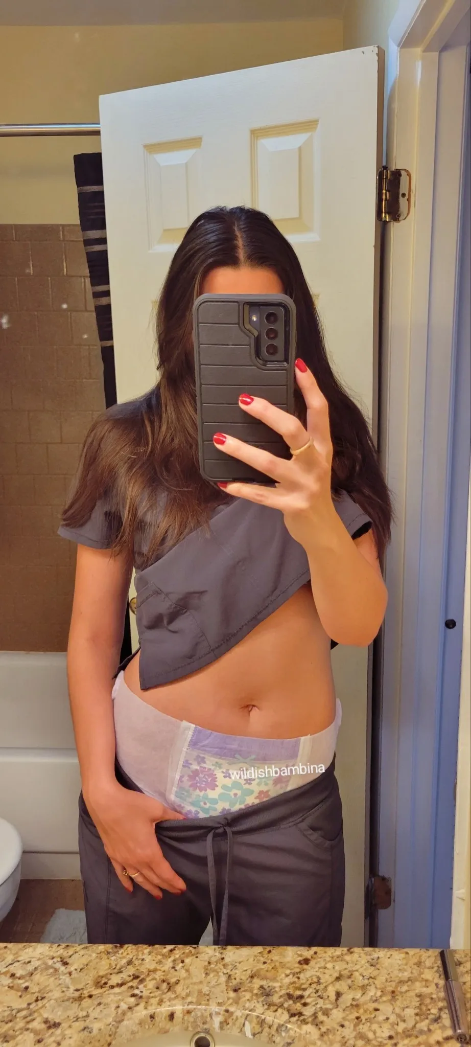 The ABDL girl pulls her pants down slightly to reveal her Goodnight diaper.
