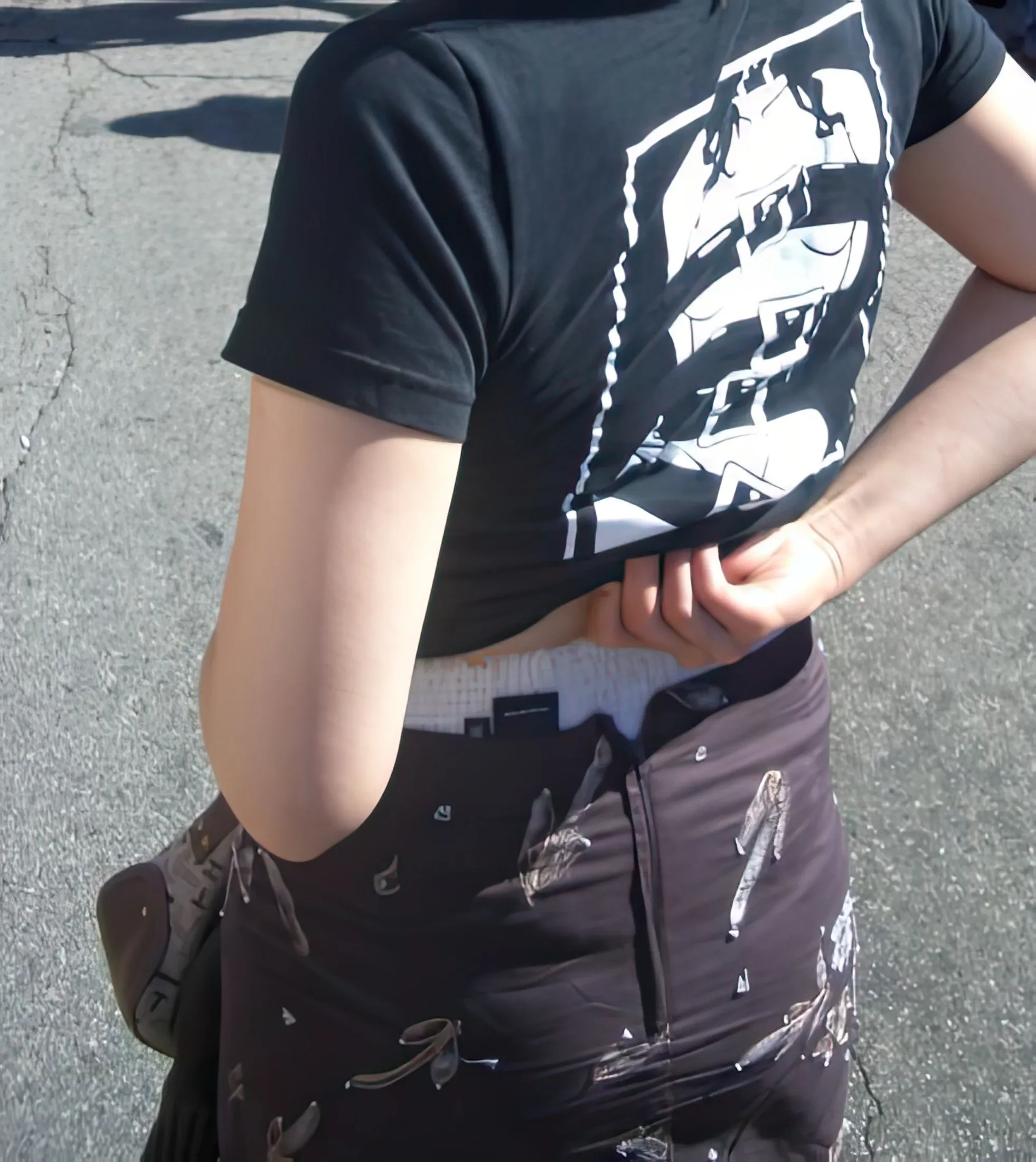 The waistband of the ABDL girl's diaper is exposed beneath her top.