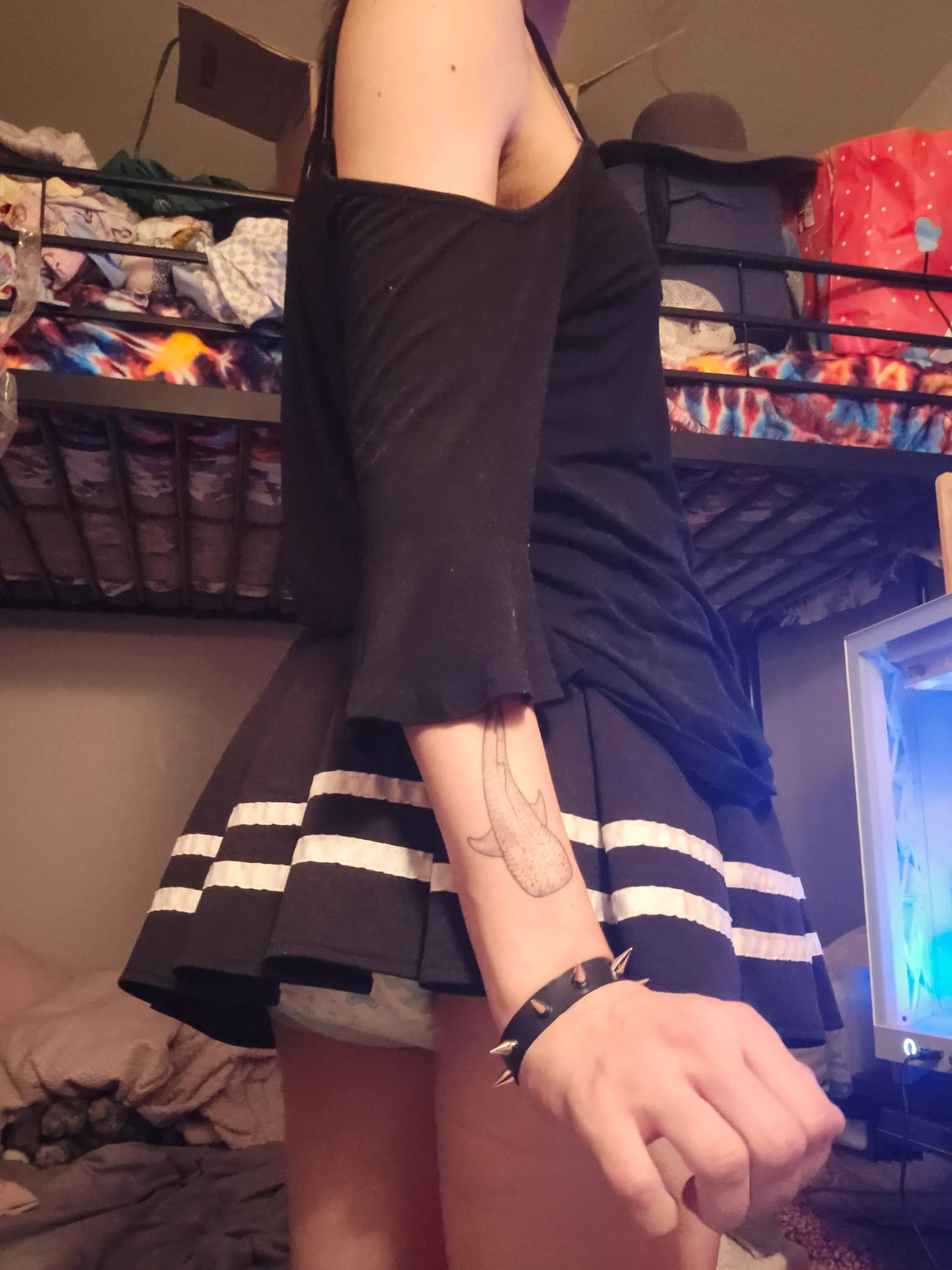 An ABDL girl is wearing a short skirt and exposing her diaper.