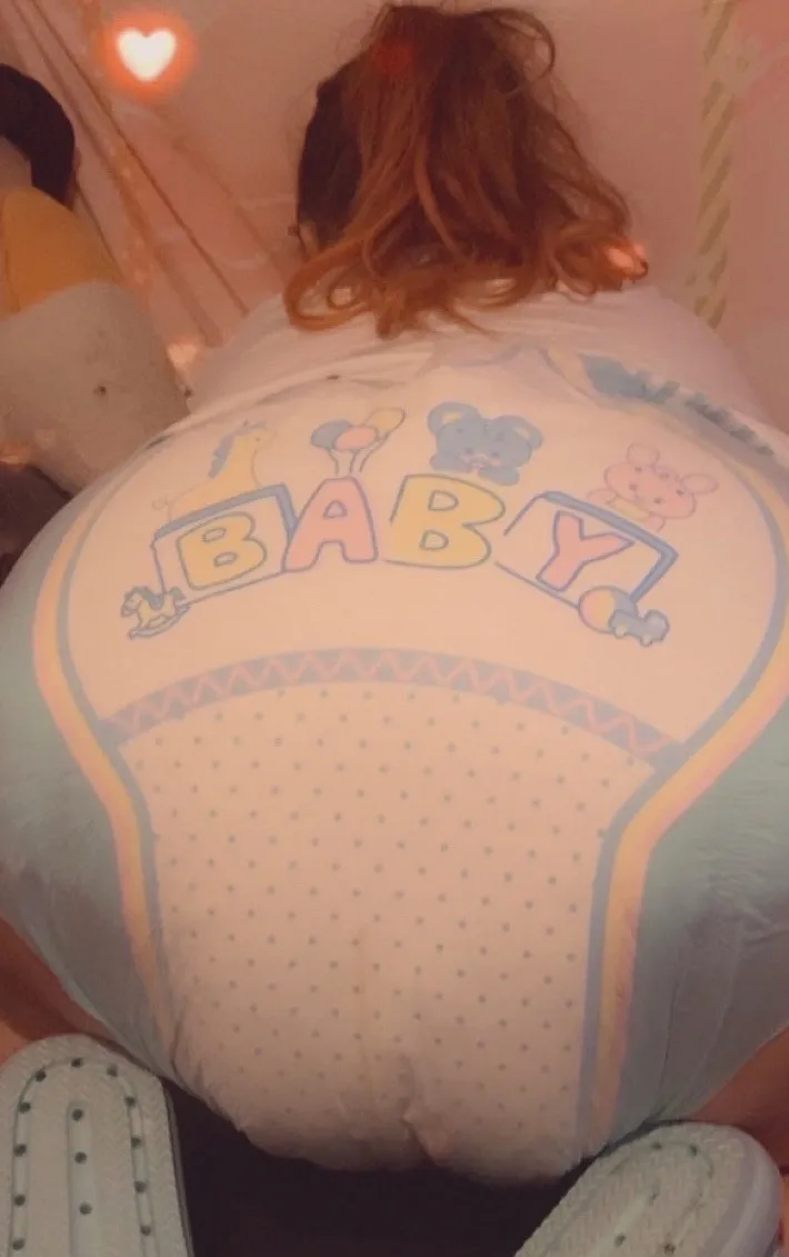 An ABDL girl is showing off her diaper in a doggy style position.