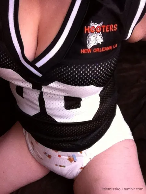An ABDL girl wears a New Orleans HOOTERS shirt and shows off her diaper.