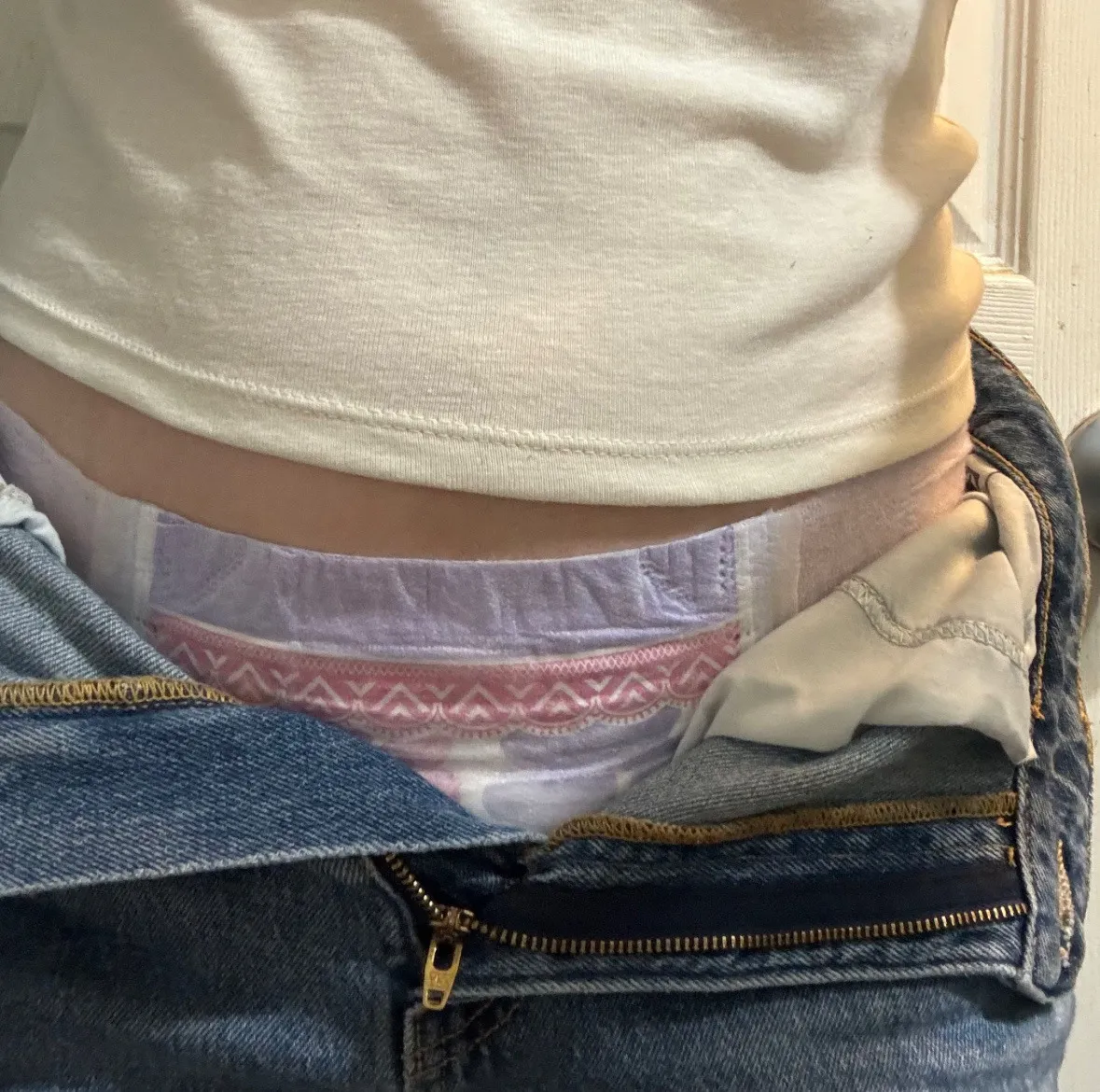 A goodnight diaper is visible through the open zipper of the ABDL girl's jeans.