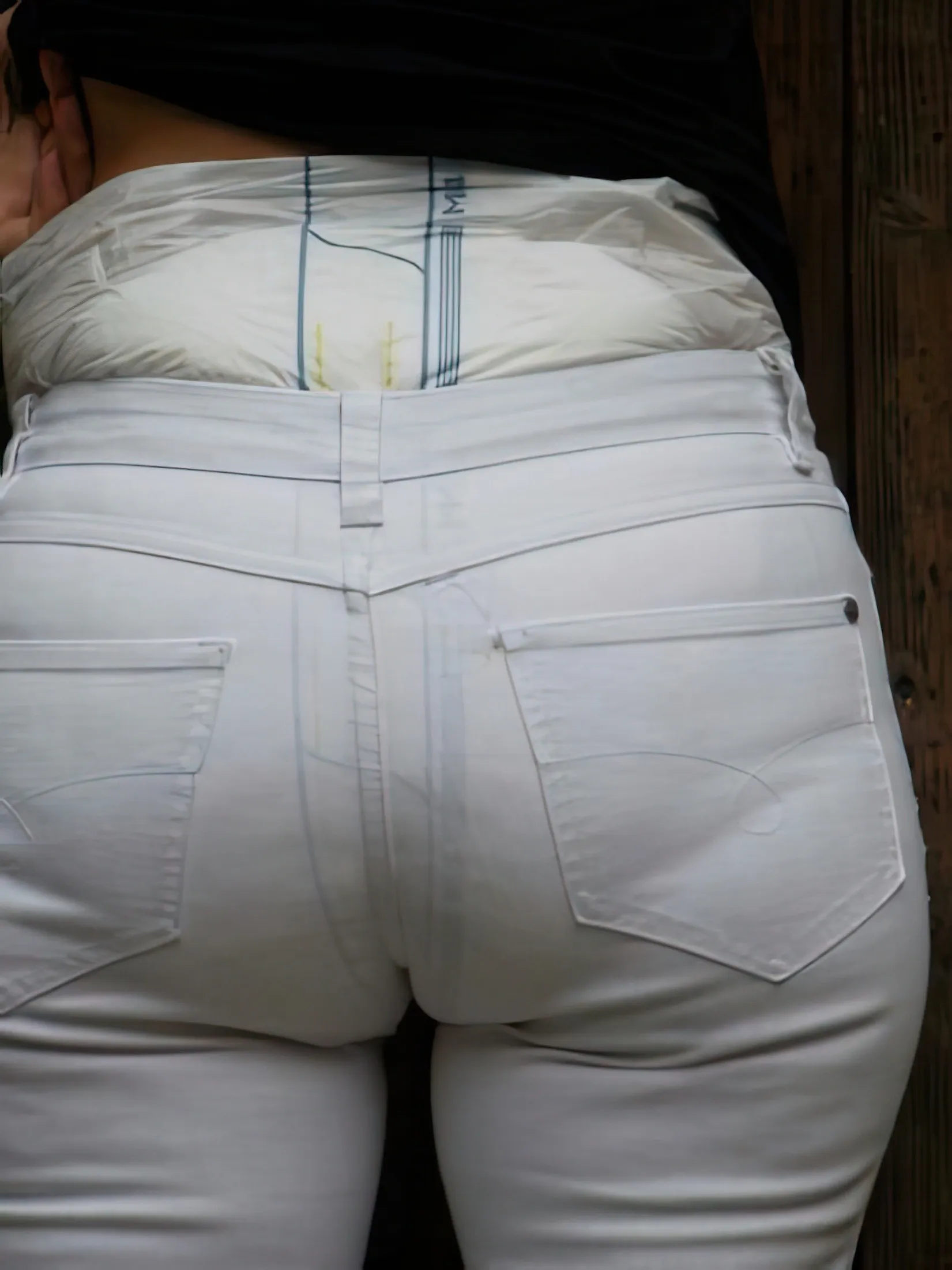 The ABDL girl's diaper is visible through her white pants.