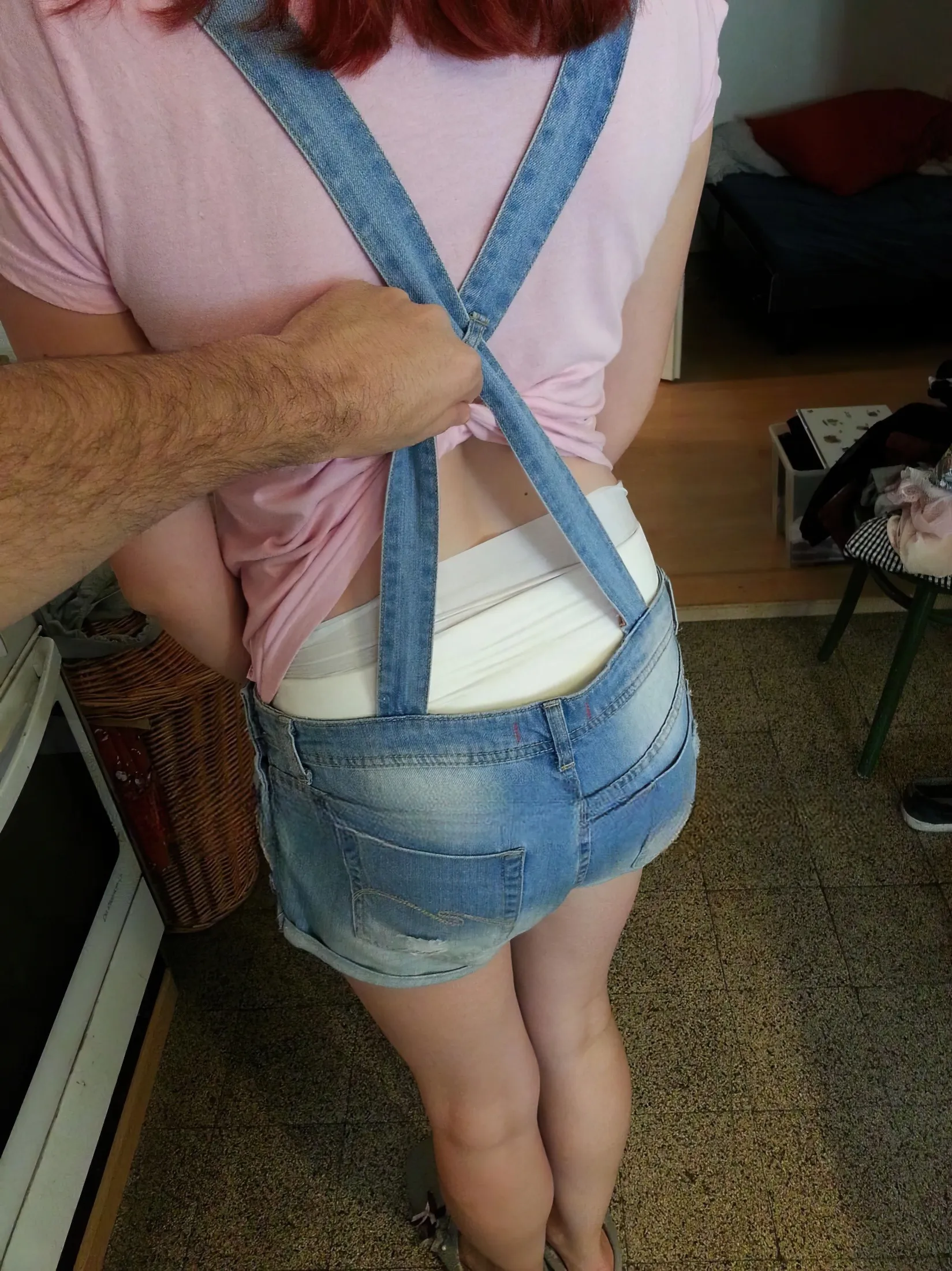 The ABDL girl was wearing suspenders, and the man lifted her clothes to expose her diaper.