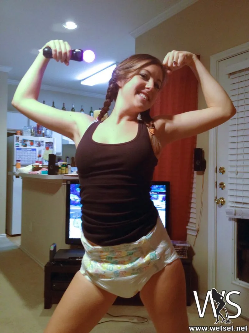 An ABDL girl strikes a pose showing off her muscles while flaunting her diaper.