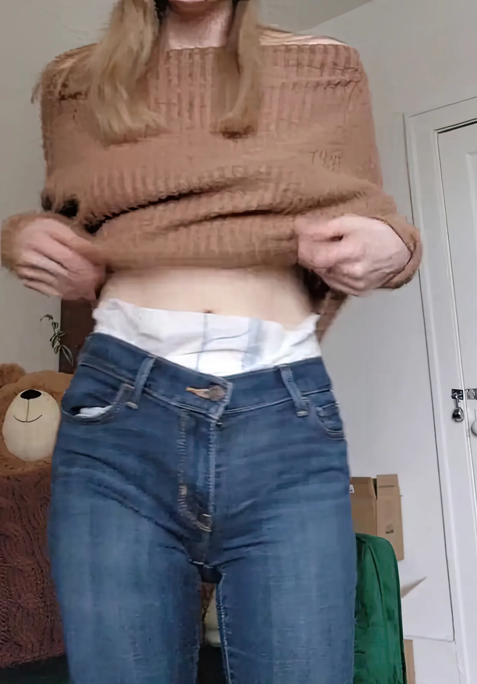 When the ABDL girl lifts her top, the diaper band is exposed over her jeans.