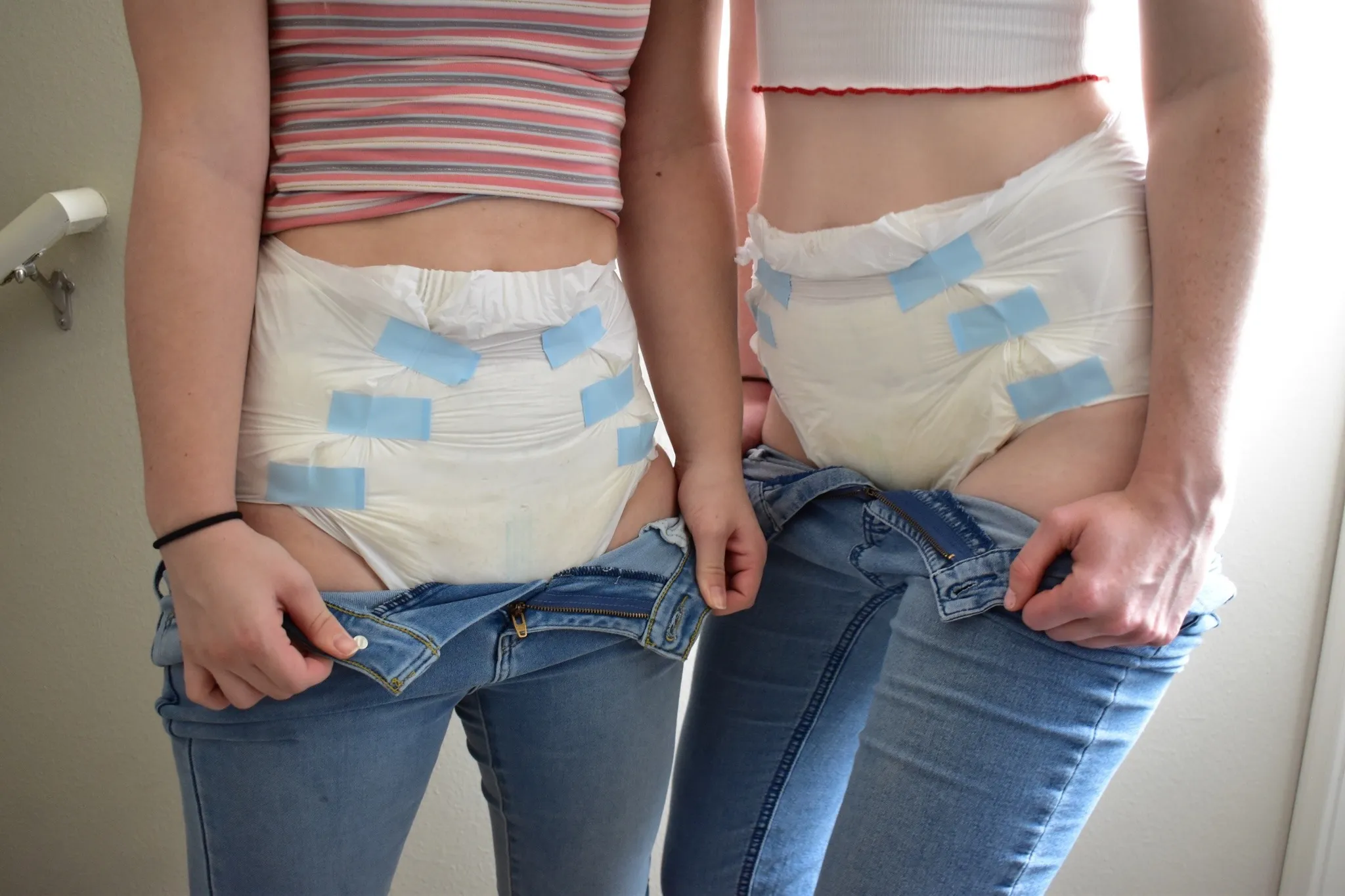 ABDL girls pull down their jeans to show off their diapers.