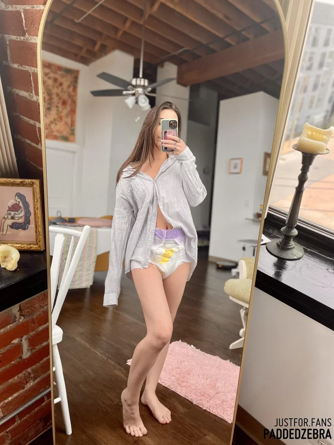 An ABDL girl took a selfie wearing a diaper in front of a mirror.