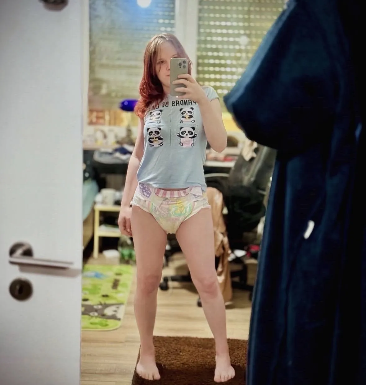 ABDL girl uses a mirror to expose her pastel-colored diaper.