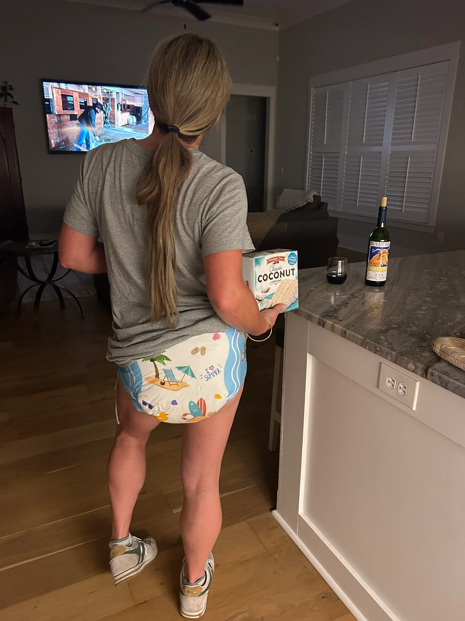 An ABDL girl holds a COCONUT product while exposing a diaper of a similar color.