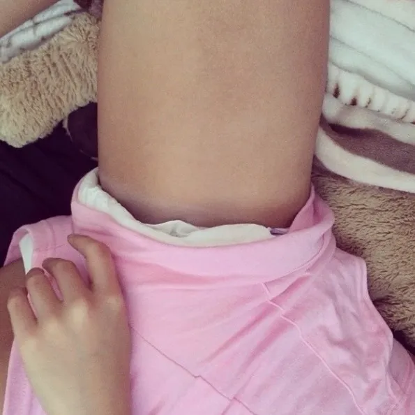 ABDL girl showing off her diaper peeking out from her pink shorts.