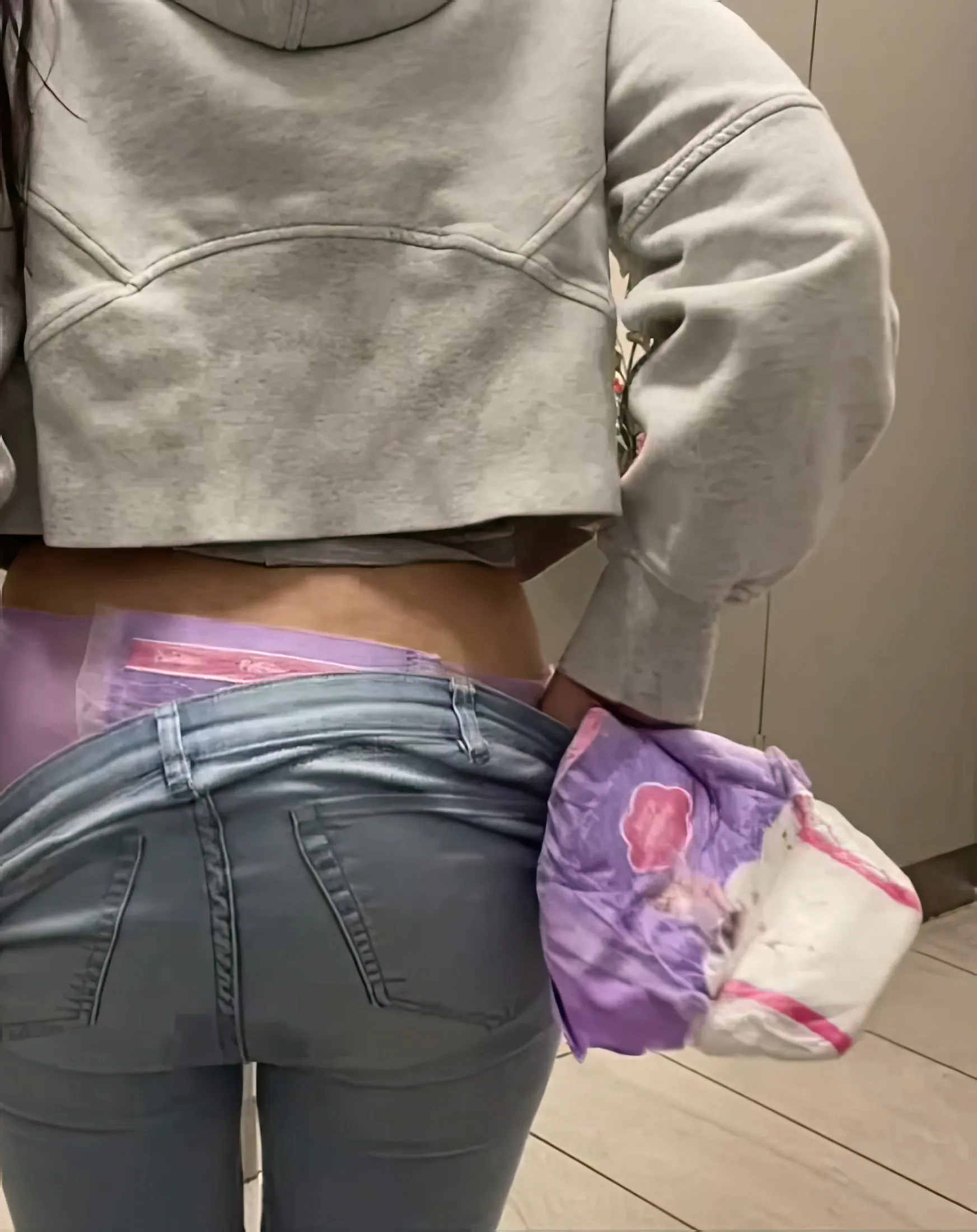 As the ABDL girl pulls down her jeans, her pull-up diaper and wet jeans are exposed.