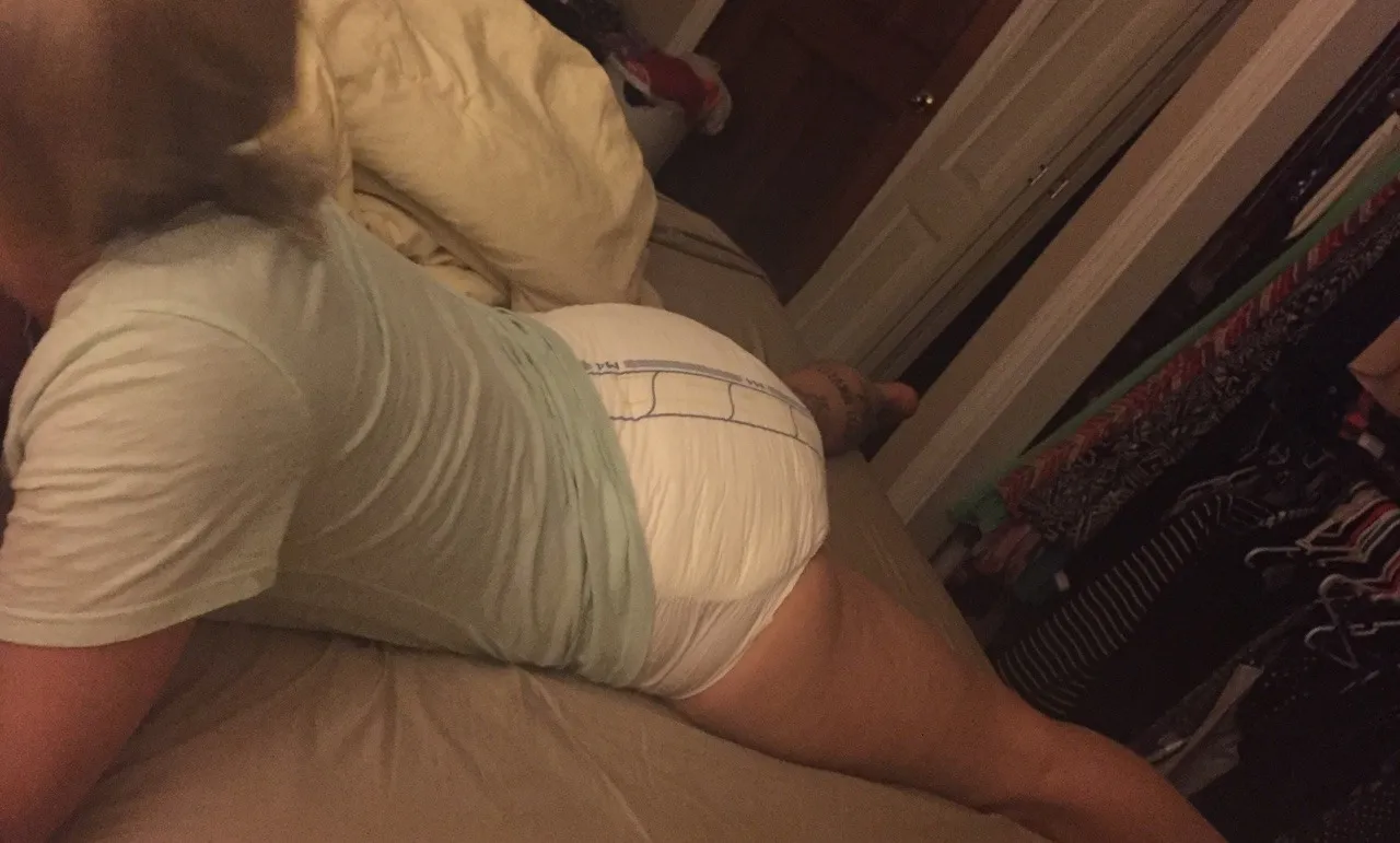 ABDL girl lying on her stomach, showing off her white diaper.