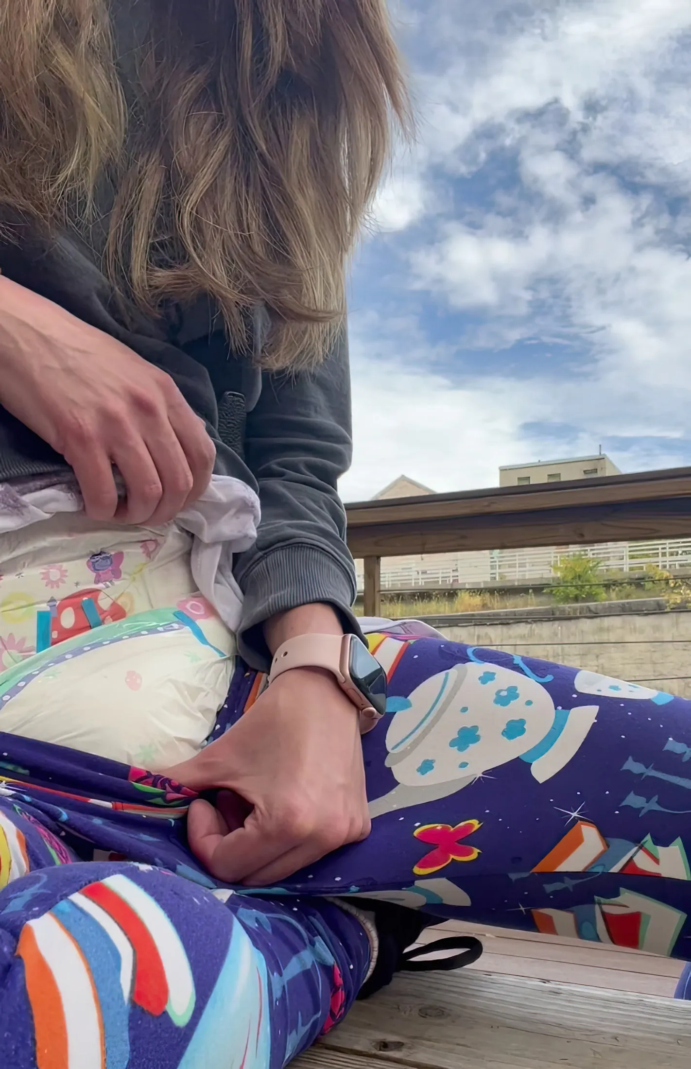 ABDL girl pulls down her leggings outdoors to show off her diaper.