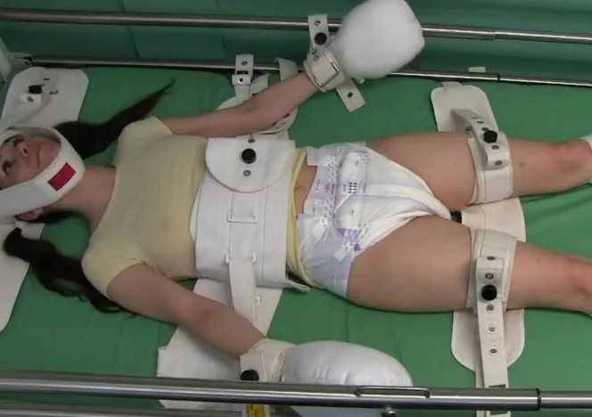 An ABDL girl is bound hand and foot, her nipples visible through her clothing, wearing a diaper.