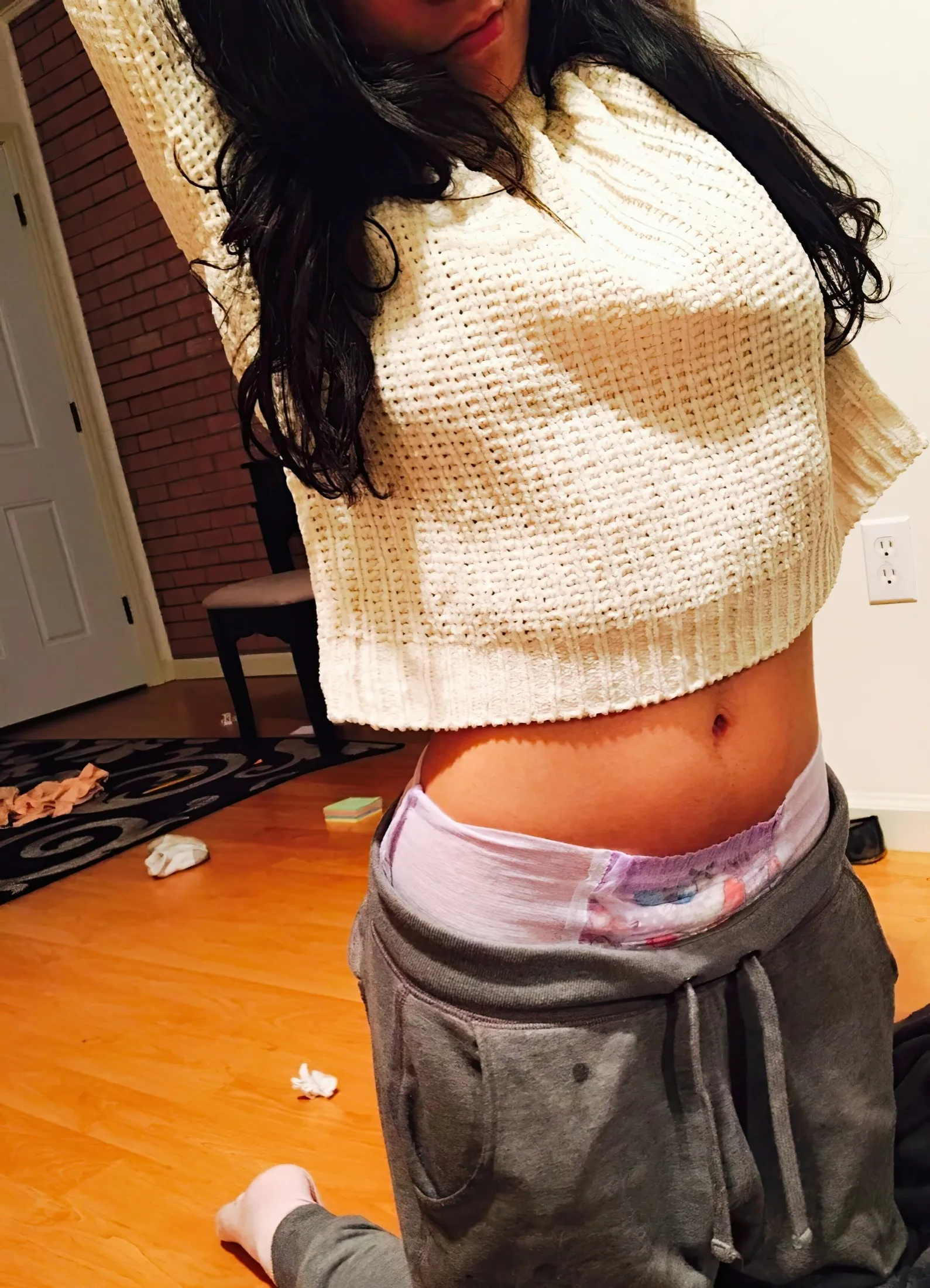 The ABDL girl flings her arms up, exposing the waistband of her pull-up diaper.