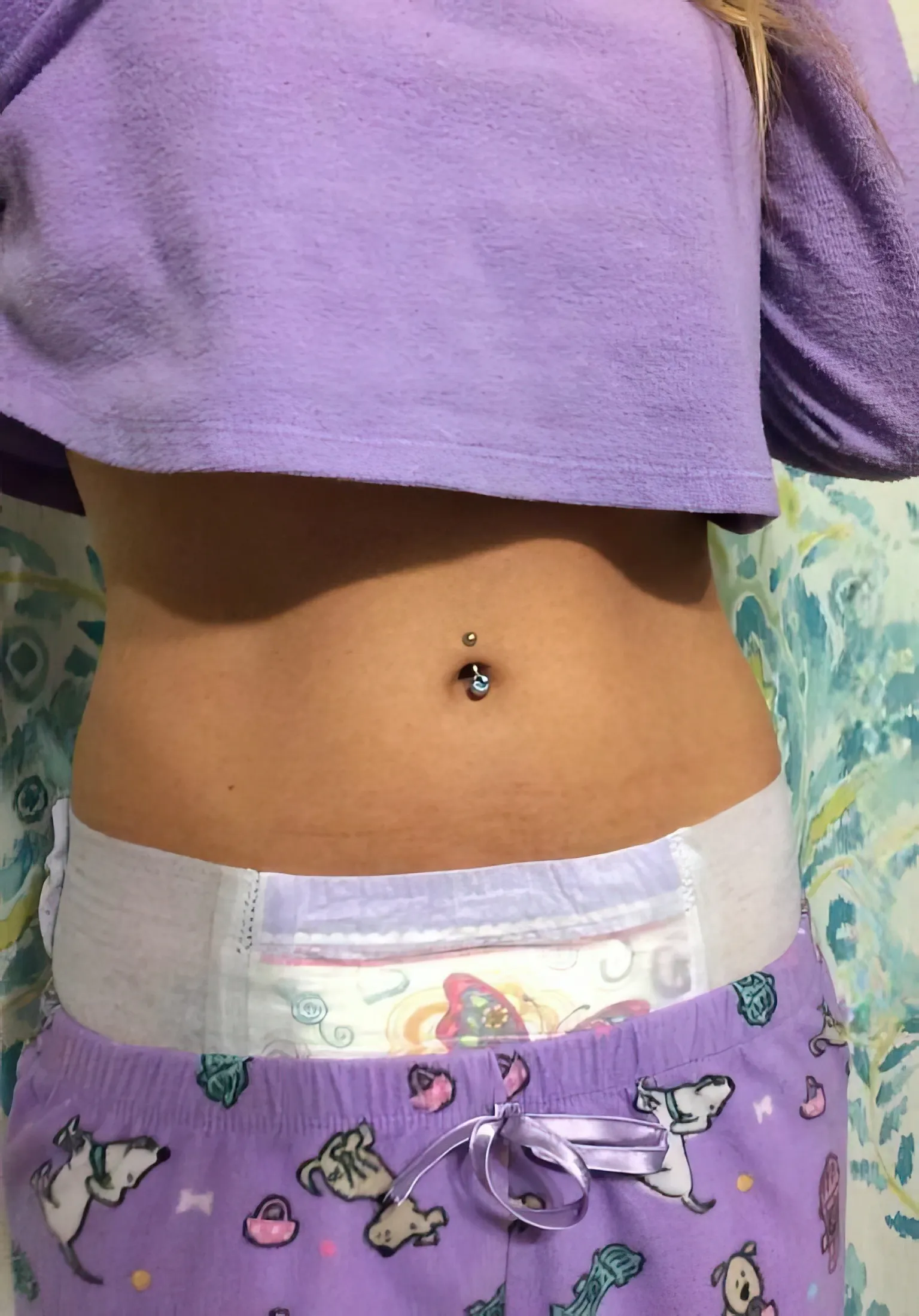 An ABDL girl looks in the mirror, makes a V sign, and exposes her diaper.
