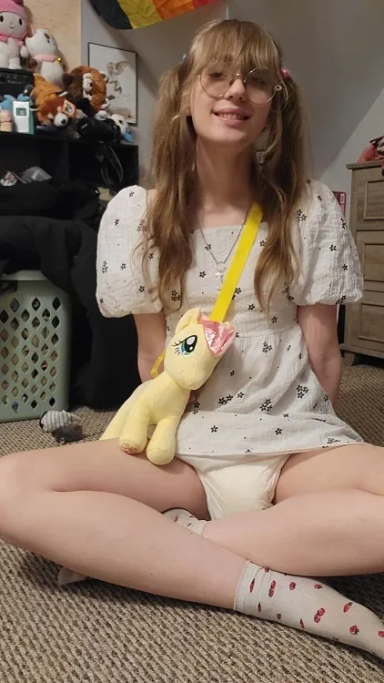ABDL woman flaunts the waistband of her pull-up diaper peeking out over her pajama bottoms.