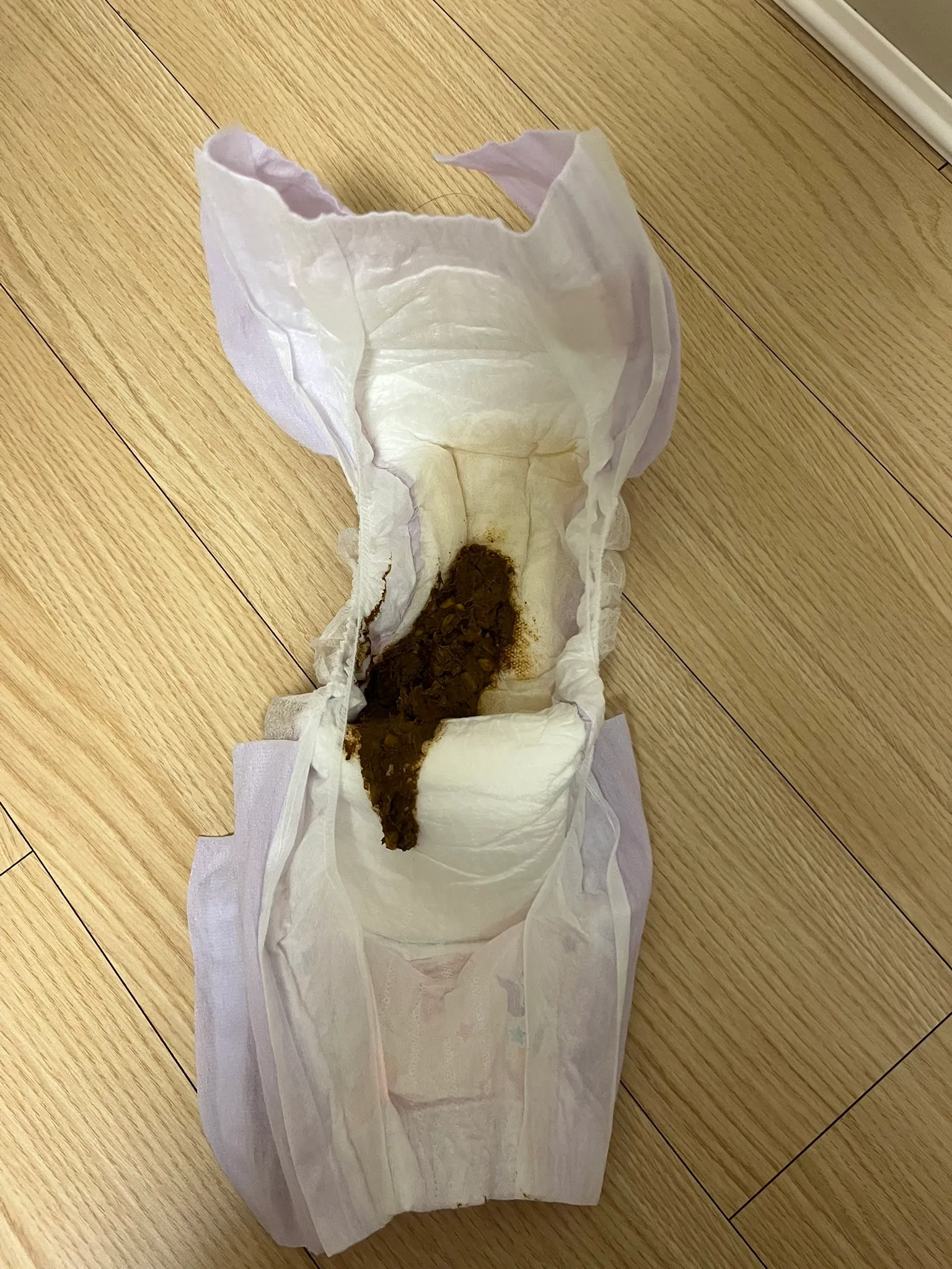 An ABDL girl poops in her pull-up diaper and spreads it on the floor.
