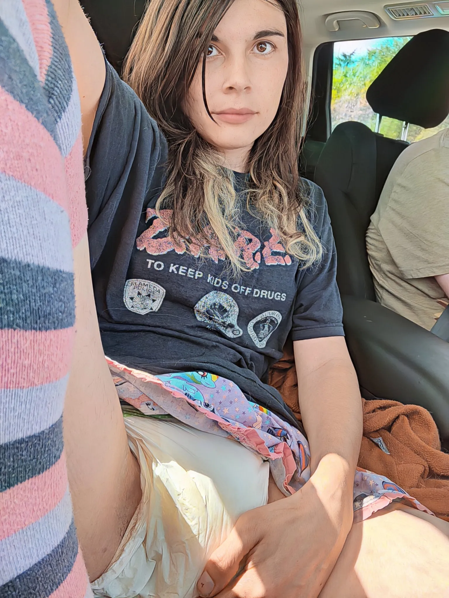 ABDL girl lifts her legs in the car and shows off her peed-in diaper.