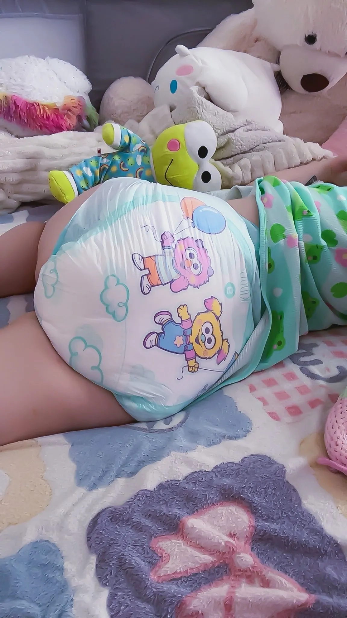 An ABDL girl lies on her side, proudly showing off her diaper.