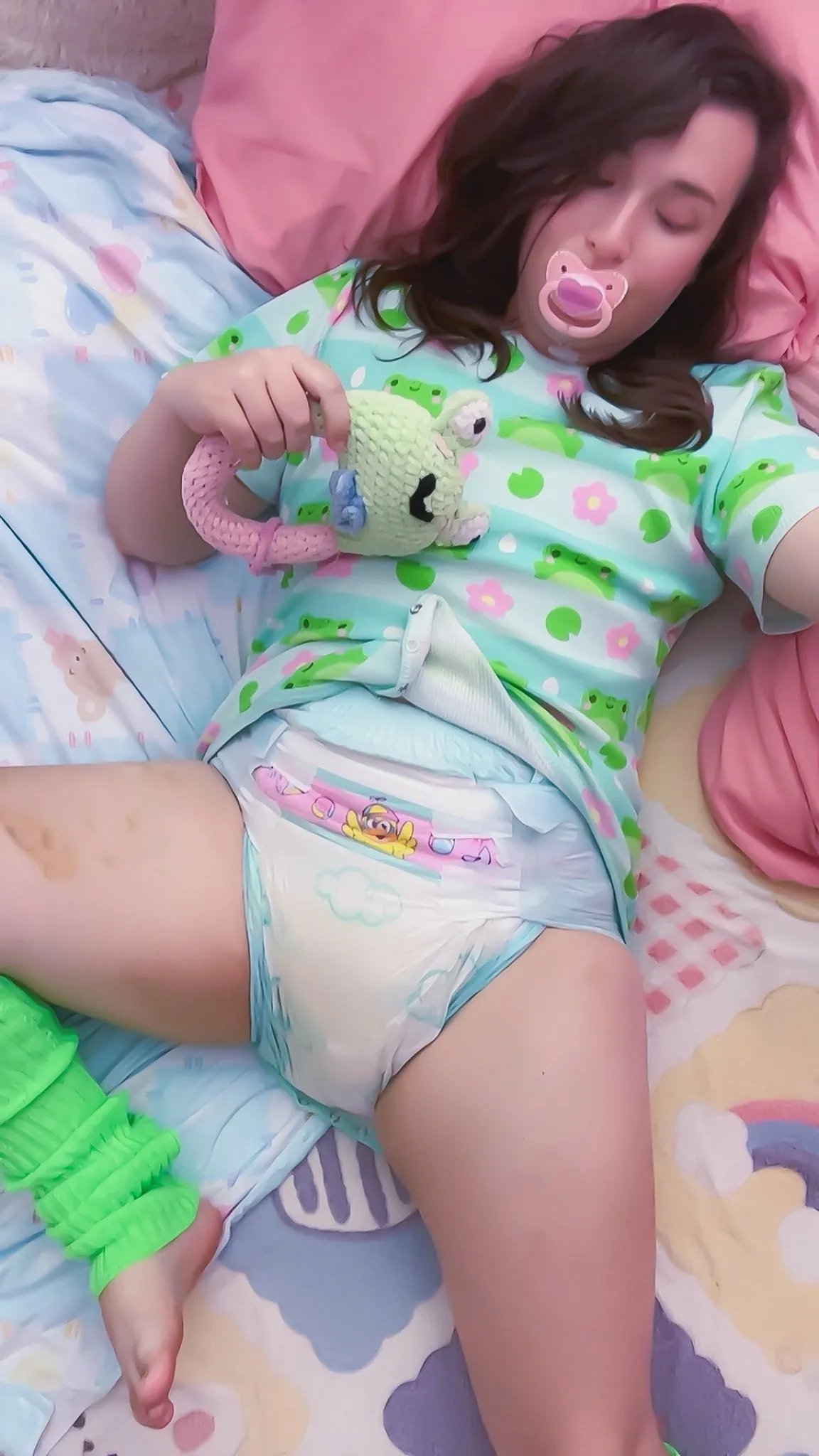 ABDL woman showing off her diaper in bed.