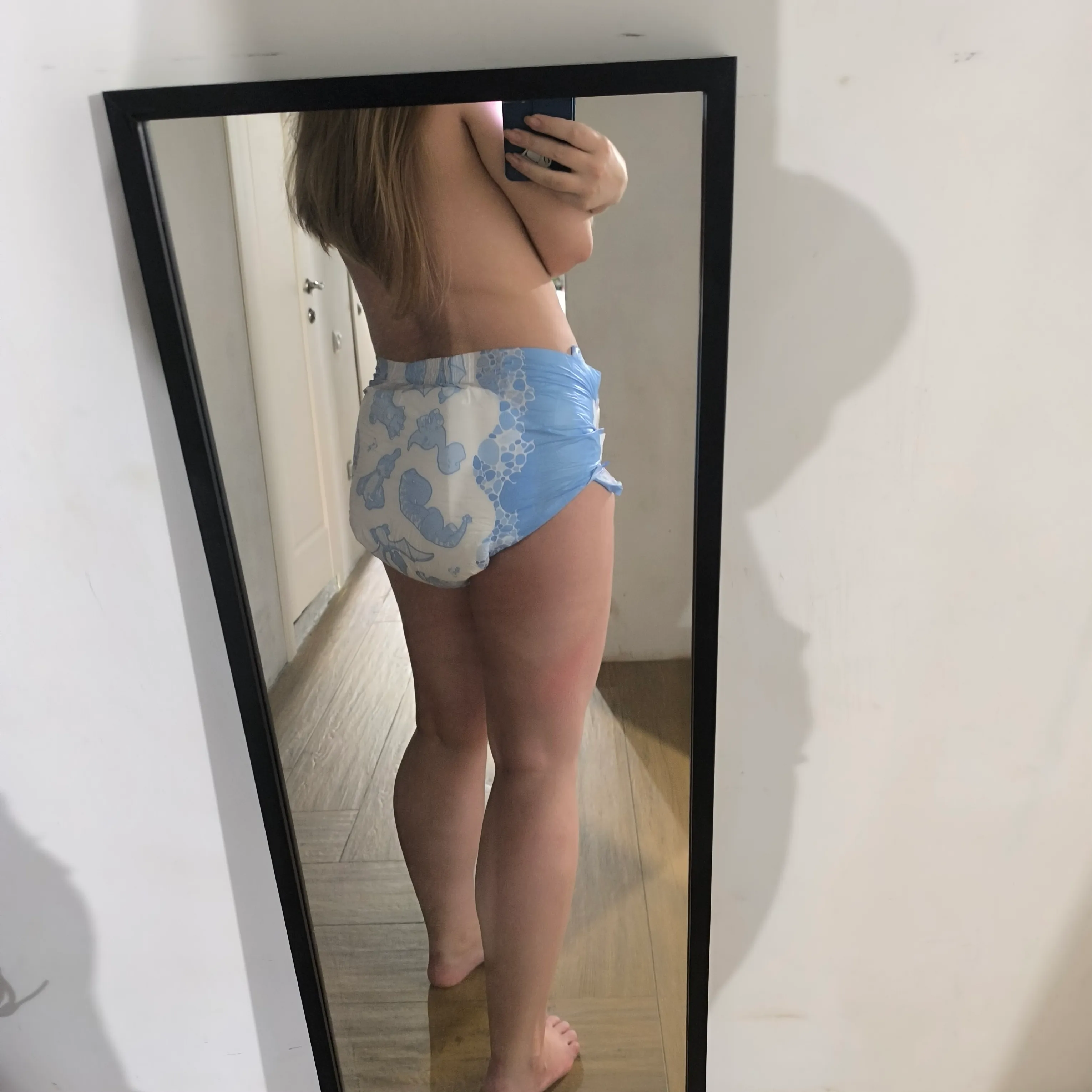ABDL girl lifts her dress to expose her diaper.