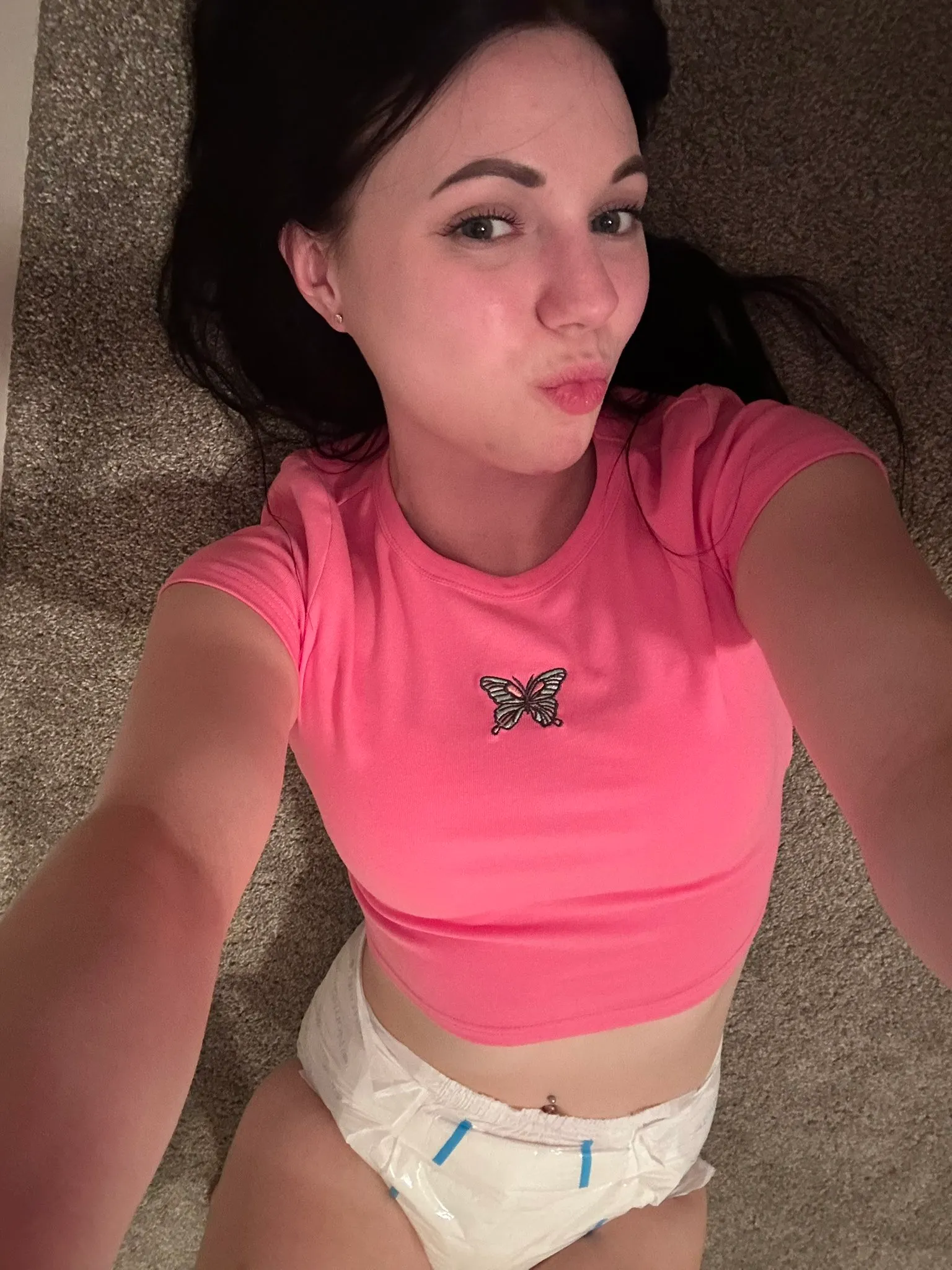 ABDL girl wearing a pink top with diaper exposure