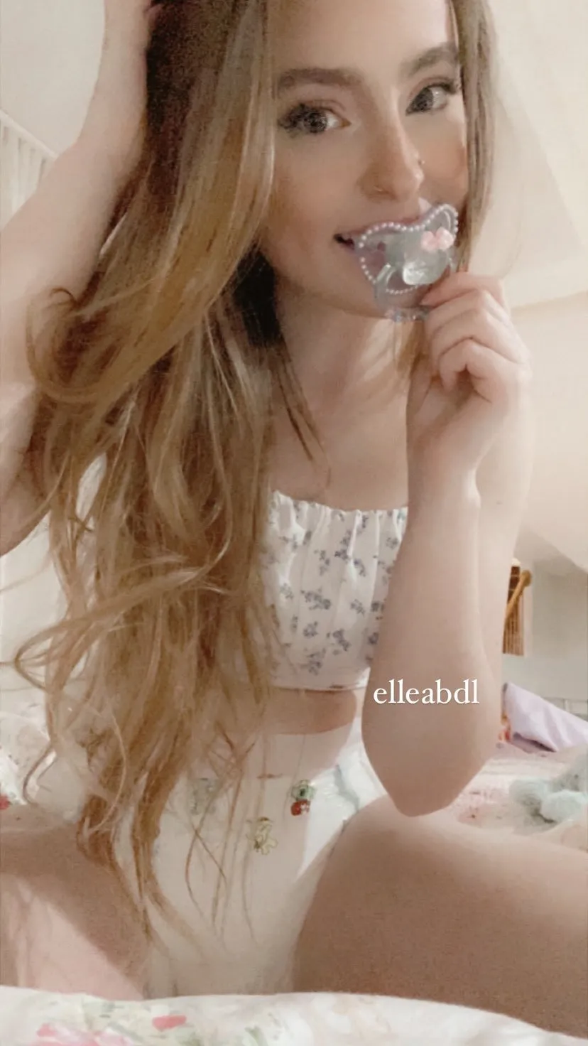 A woman flaunting her fake nipples and white diapers.